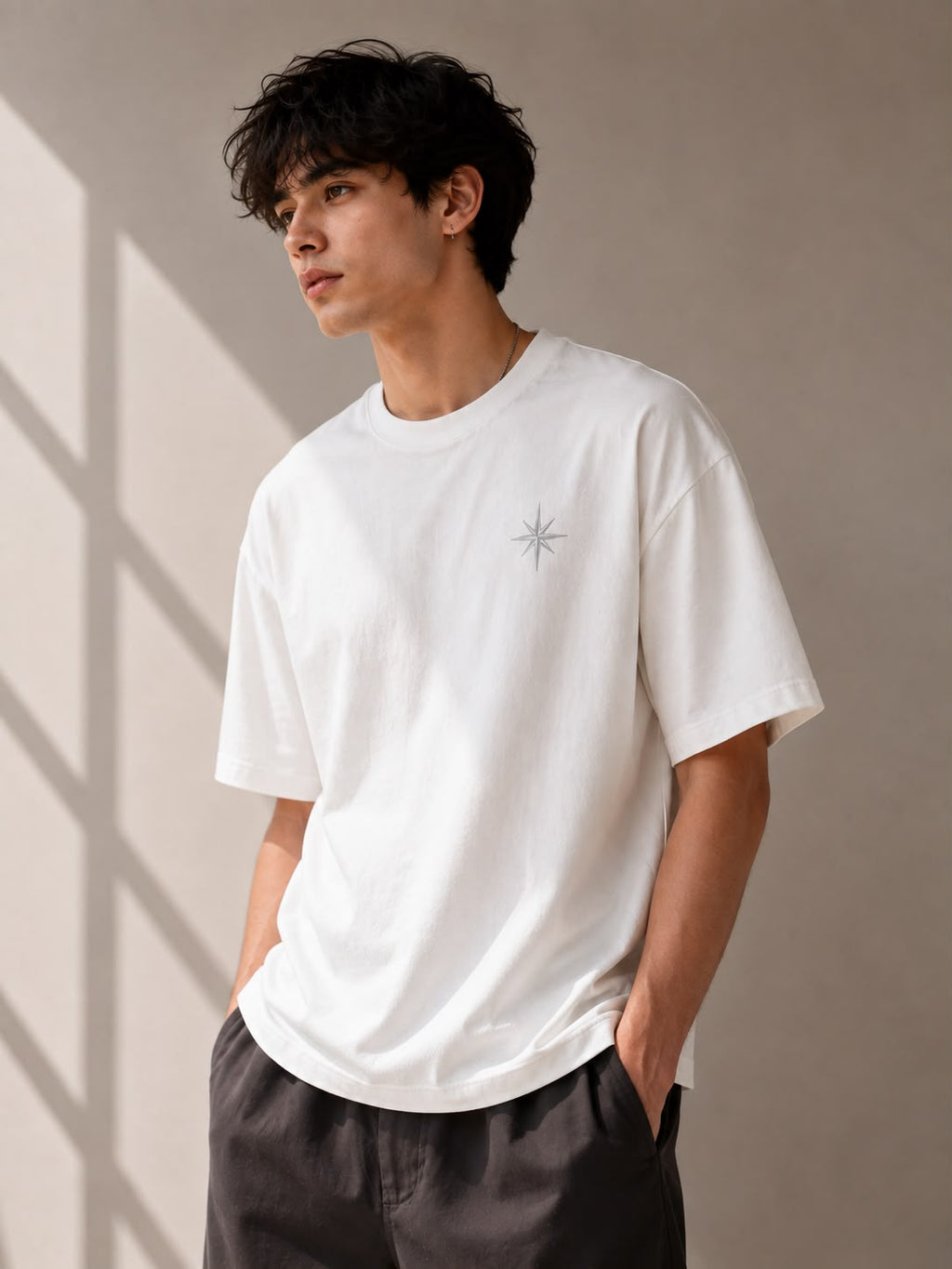 Off White — model in the Oversized Graphic T-Shirt with a small star emblem on the chest, three-quarter view